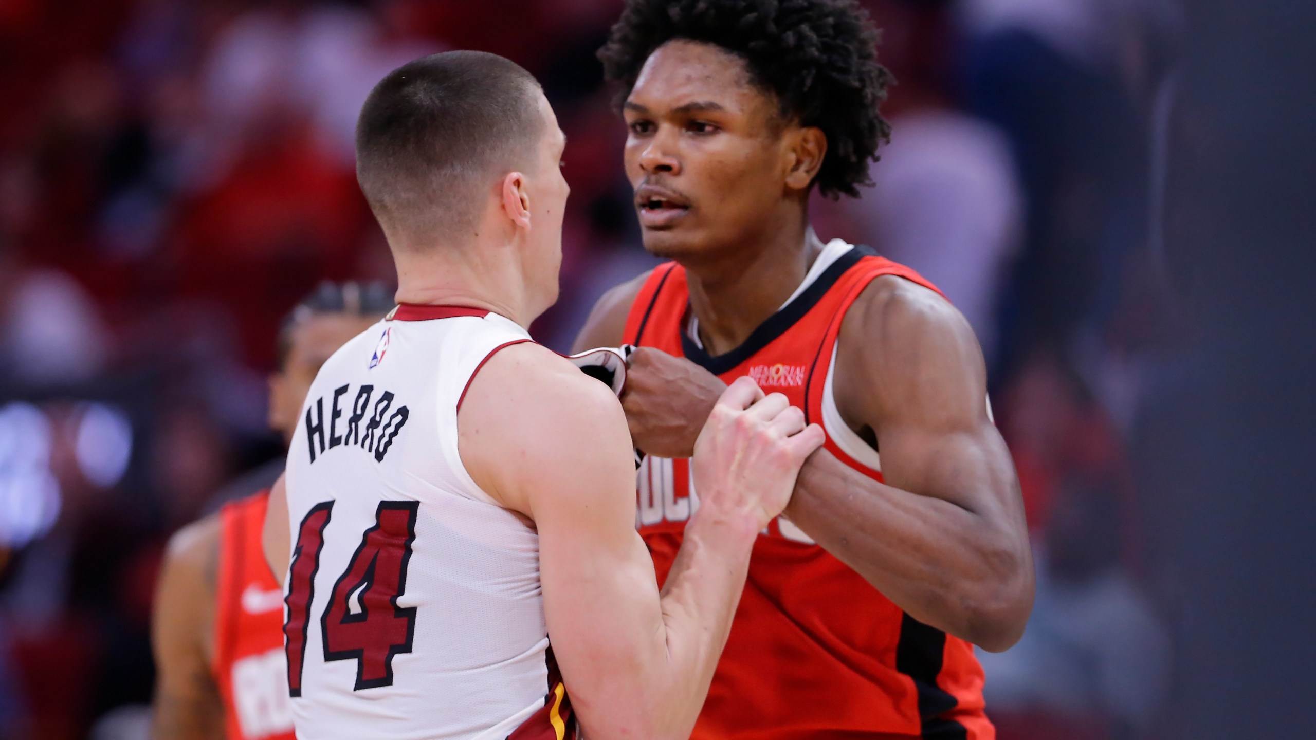 Houston Rockets forward Amen Thompson, right, and Miami Heat guard Tyler Herro (14) tug on each other before Thompson throws Herro to the court sparking a bench clearing brawl resulting in multiple ejections for both teams during the second half of an NBA basketball game Sunday, Dec. 29, 2024, in Houston. (AP Photo/Michael Wyke)