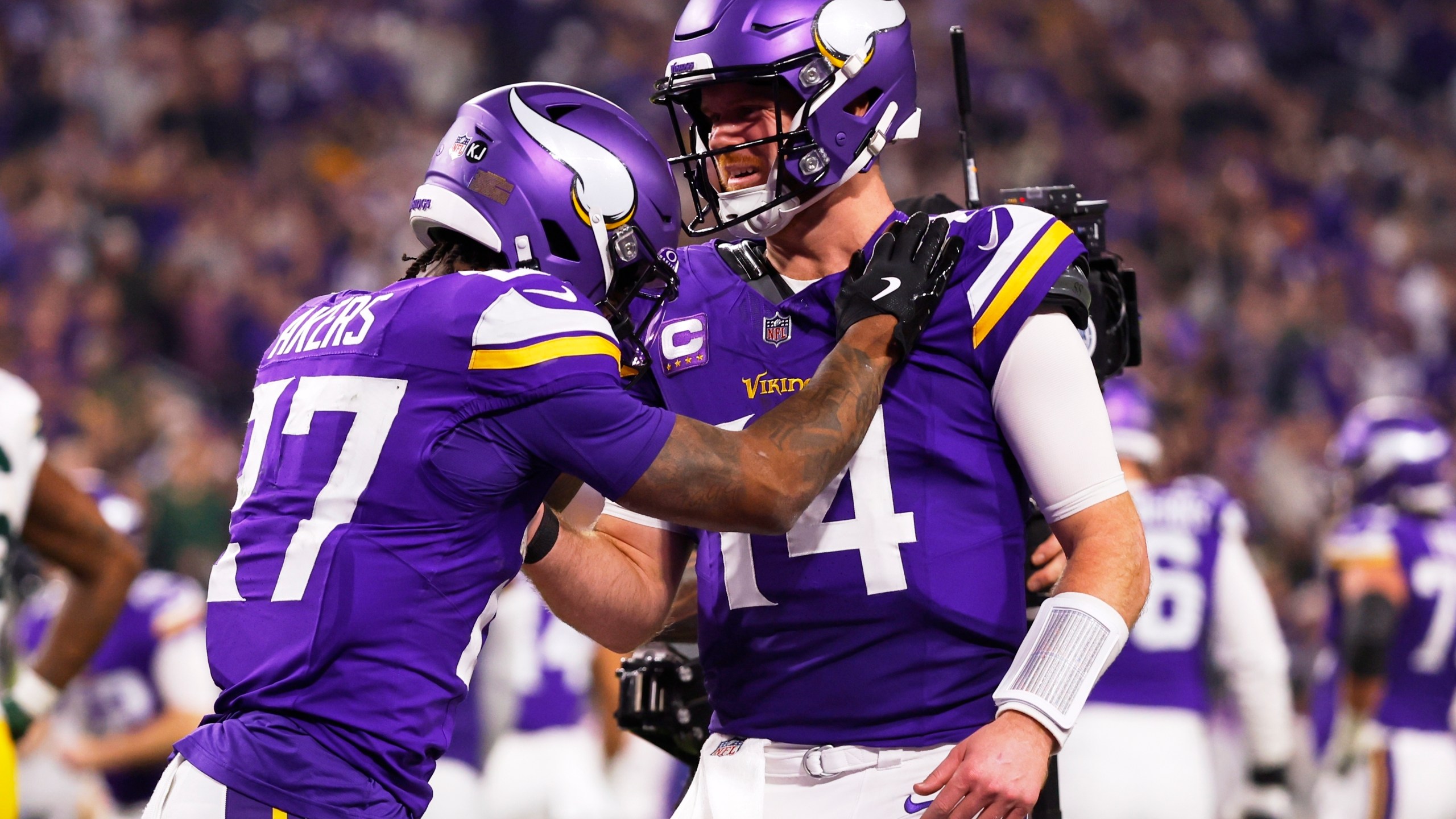 Minnesota Vikings' Sam Darnold congratulates Cam Akers on a touchdown catch during the second half of an NFL football game against the Green Bay Packers Sunday, Dec. 29, 2024, in Minneapolis. (AP Photo/Bruce Kluckhohn)