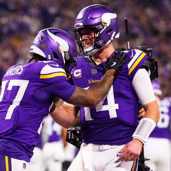 Minnesota Vikings' Sam Darnold congratulates Cam Akers on a touchdown catch during the second half of an NFL football game against the Green Bay Packers Sunday, Dec. 29, 2024, in Minneapolis. (AP Photo/Bruce Kluckhohn)