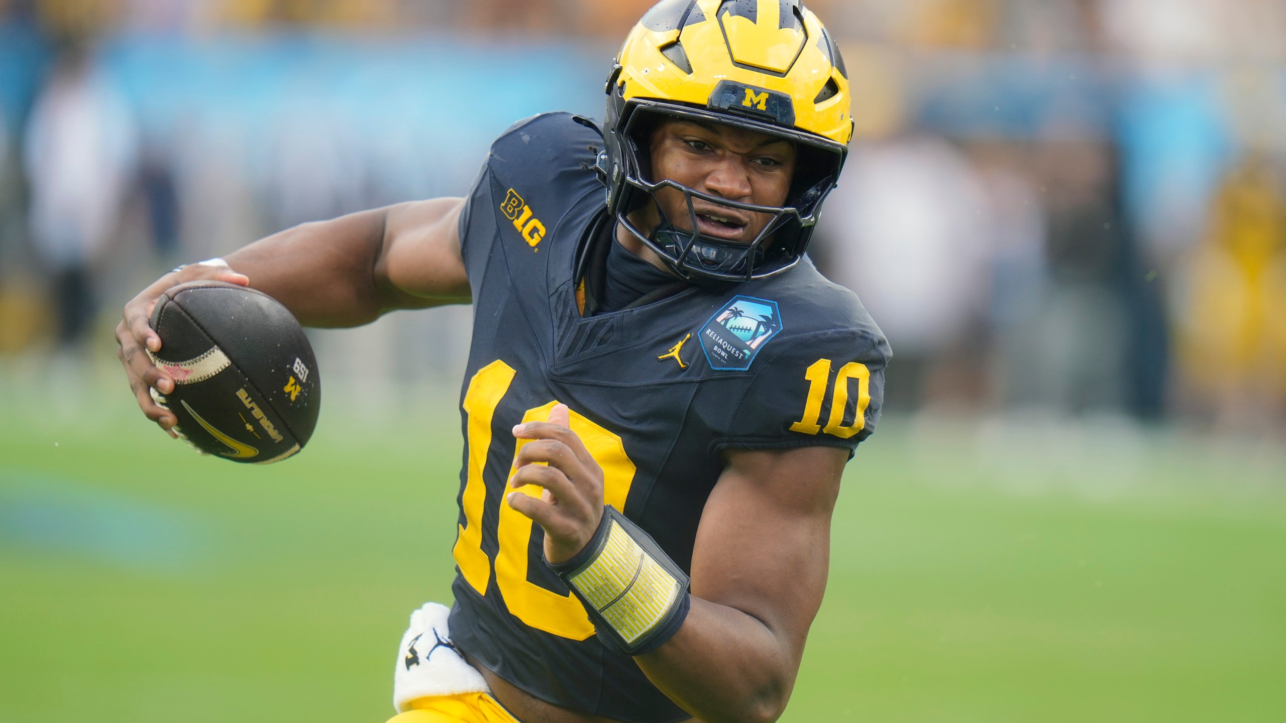 Michigan quarterback Alex Orji picks up yards against Alabama during the first half of the ReliaQuest Bowl NCAA college football game Tuesday, Dec. 31, 2024, in Tampa, Fla. (AP Photo/Chris O'Meara)