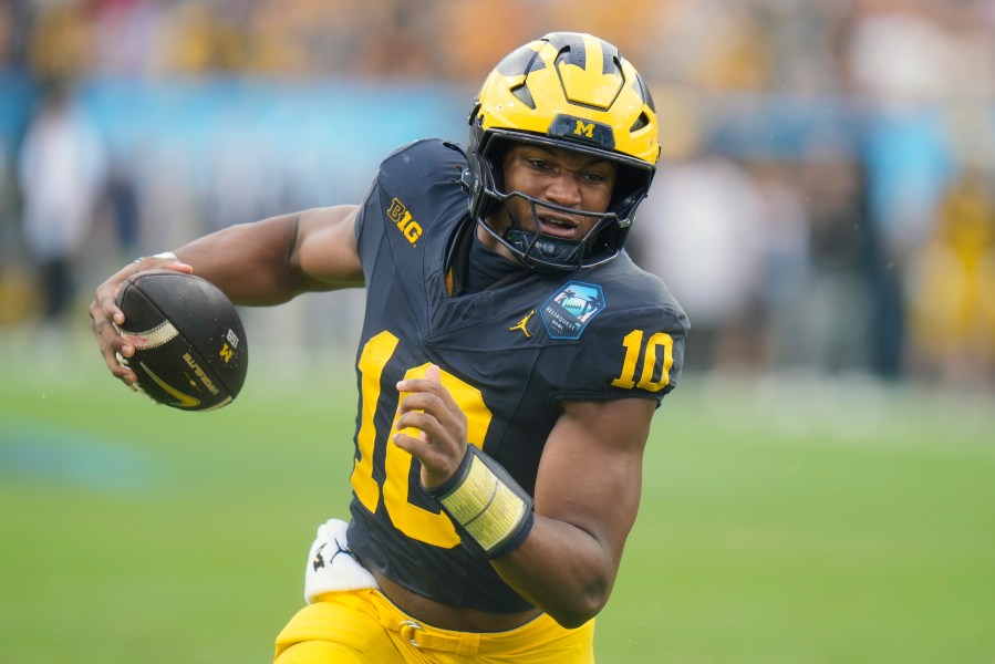 Michigan quarterback Alex Orji picks up yards against Alabama during the first half of the ReliaQuest Bowl NCAA college football game Tuesday, Dec. 31, 2024, in Tampa, Fla. (AP Photo/Chris O'Meara)