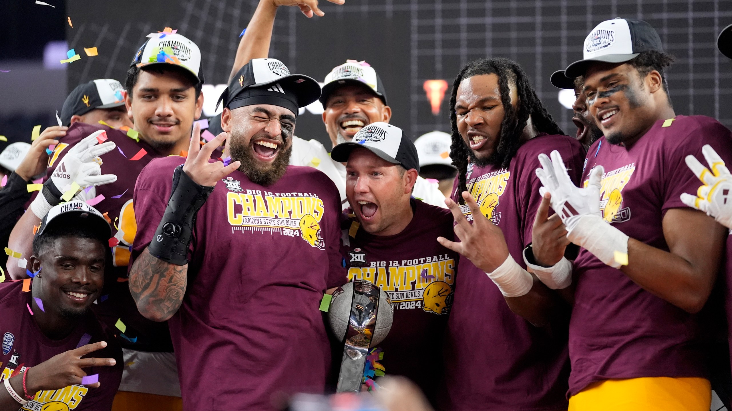 Ariona State head coach Kenny Dillingham, center, celebrates with his team after their win in the Big 12 Conference championship NCAA college football game against Iowa State, in Arlington, Texas, Saturday Dec. 7, 2024. (AP Photo/LM Otero)