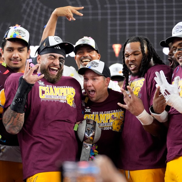 Ariona State head coach Kenny Dillingham, center, celebrates with his team after their win in the Big 12 Conference championship NCAA college football game against Iowa State, in Arlington, Texas, Saturday Dec. 7, 2024. (AP Photo/LM Otero)