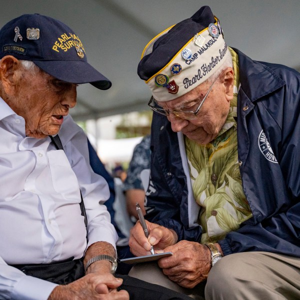 FILE - Pearl Harbor survivors Harry Chandler, 102, left, and Herb Elfring, 101, talk during the 82nd Pearl Harbor Remembrance Day ceremony on Dec. 7, 2023, at Pearl Harbor in Honolulu. (AP Photo/Mengshin Lin, File)