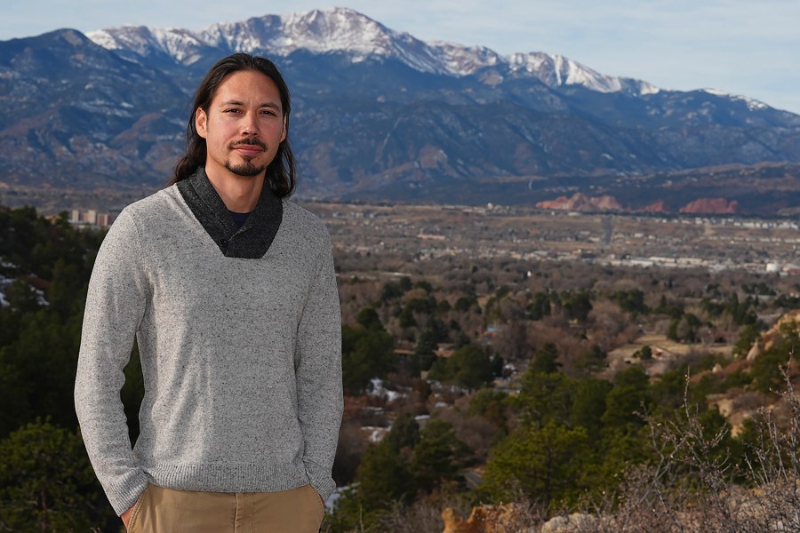 Lane Belone poses with Pikes Peak in the background on an overlook in Palmer Park, Thursday, Dec. 19, 2024, in Colorado Springs, Colo. (AP Photo/David Zalubowski)