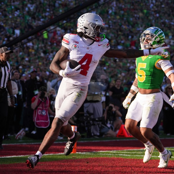 Ohio State wide receiver Jeremiah Smith (4) gestures as he scores a touchdown against Oregon defensive back Kobe Savage (5) during the first half in the quarterfinals of the Rose Bowl College Football Playoff, Wednesday, Jan. 1, 2025, in Pasadena, Calif. (AP Photo/Mark J. Terrill)