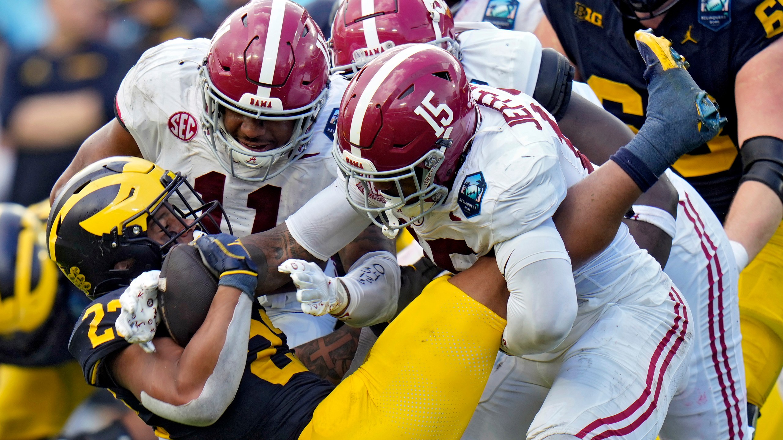 Alabama linebacker Jihaad Campbell (11) and linebacker Justin Jefferson (15) team up to stop Michigan running back Jordan Marshall (23) during the first half of the ReliaQuest Bowl NCAA college football game Tuesday, Dec. 31, 2024, in Tampa, Fla. (AP Photo/Chris O'Meara)