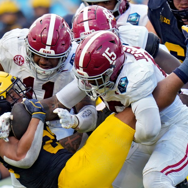 Alabama linebacker Jihaad Campbell (11) and linebacker Justin Jefferson (15) team up to stop Michigan running back Jordan Marshall (23) during the first half of the ReliaQuest Bowl NCAA college football game Tuesday, Dec. 31, 2024, in Tampa, Fla. (AP Photo/Chris O'Meara)