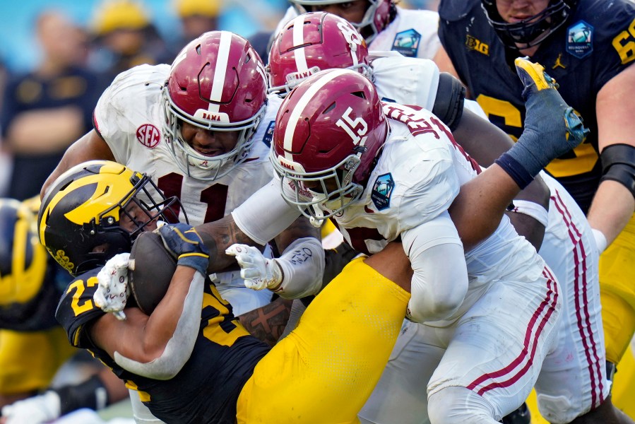 Alabama linebacker Jihaad Campbell (11) and linebacker Justin Jefferson (15) team up to stop Michigan running back Jordan Marshall (23) during the first half of the ReliaQuest Bowl NCAA college football game Tuesday, Dec. 31, 2024, in Tampa, Fla. (AP Photo/Chris O'Meara)