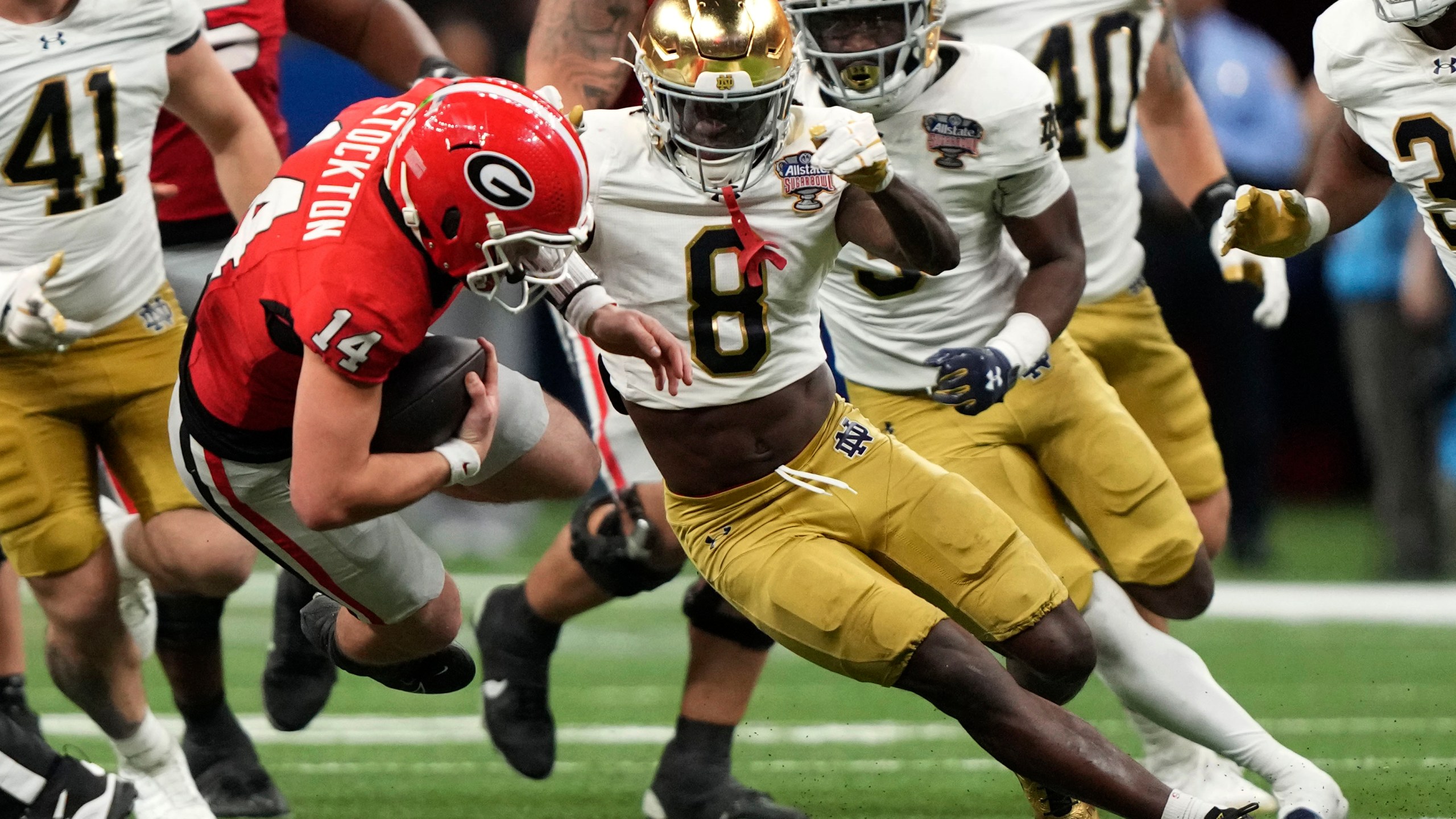 Georgia quarterback Gunner Stockton (14) is tackled by Notre Dame safety Adon Shuler (8) during the second half in the quarterfinals of a College Football Playoff, Thursday, Jan. 2, 2025, in New Orleans. (AP Photo/Gerald Herbert)