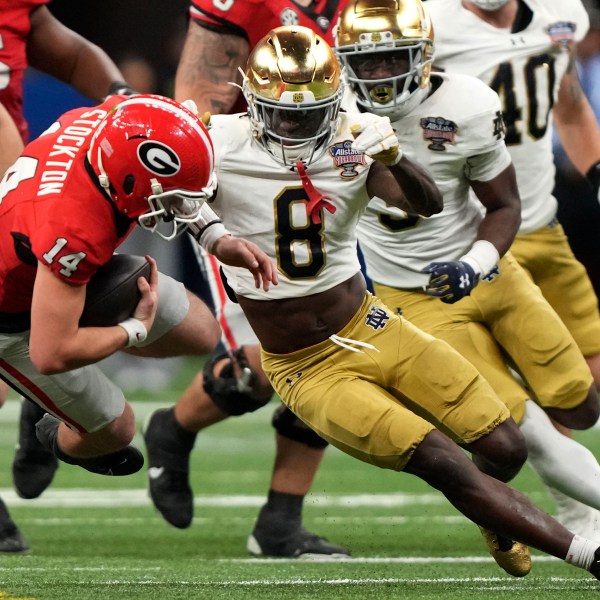 Georgia quarterback Gunner Stockton (14) is tackled by Notre Dame safety Adon Shuler (8) during the second half in the quarterfinals of a College Football Playoff, Thursday, Jan. 2, 2025, in New Orleans. (AP Photo/Gerald Herbert)