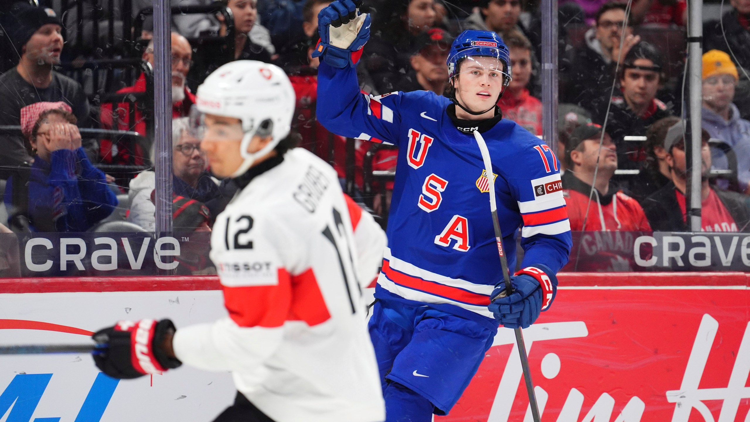 USA forward Danny Nelson (17) celebrates his goal as Switzerland forward Kimo Gruber (12) skates by during the first period of a quarterfinal match at the IIHF World Junior Hockey Championship in Ottawa, Ontario Thursday, Jan. 2, 2025. (Sean Kilpatrick/The Canadian Press via AP)