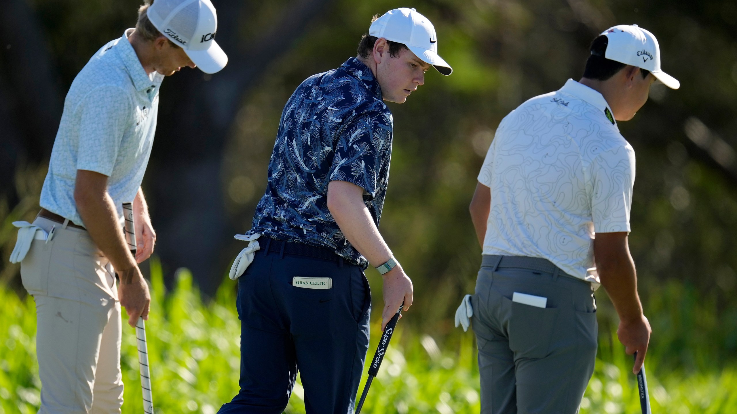 From left; Will Zalatoris, Robert MacIntyre, of Scotland, and Si Woo Kim, of South Korea, walks across the fourth green during the first round of The Sentry golf event, Thursday, Jan. 2, 2025, at Kapalua Plantation Course in Kapalua, Hawaii. (AP Photo/Matt York)