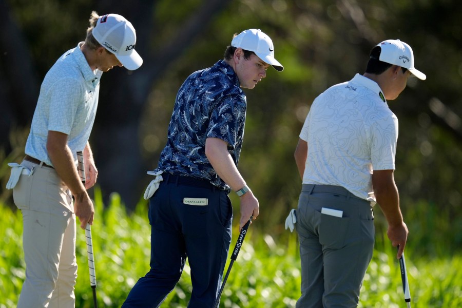 From left; Will Zalatoris, Robert MacIntyre, of Scotland, and Si Woo Kim, of South Korea, walks across the fourth green during the first round of The Sentry golf event, Thursday, Jan. 2, 2025, at Kapalua Plantation Course in Kapalua, Hawaii. (AP Photo/Matt York)