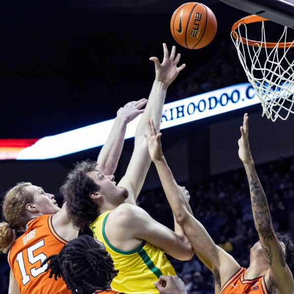 Oregon center Nate Bittle (32) shoot against Illinois forward Will Riley (7) during the first half of an NCAA college basketball game in Eugene, Ore., Thursday, Jan. 2, 2025. (AP Photo/Thomas Boyd)