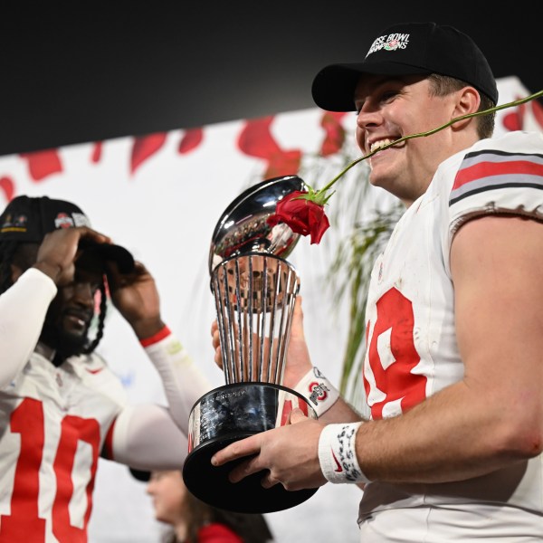 Ohio State quarterback Will Howard (18) celebrates with the trophy after the quarterfinals of the Rose Bowl College Football Playoff against Oregon, Wednesday, Jan. 1, 2025, in Pasadena, Calif. (AP Photo/Kyusung Gong)