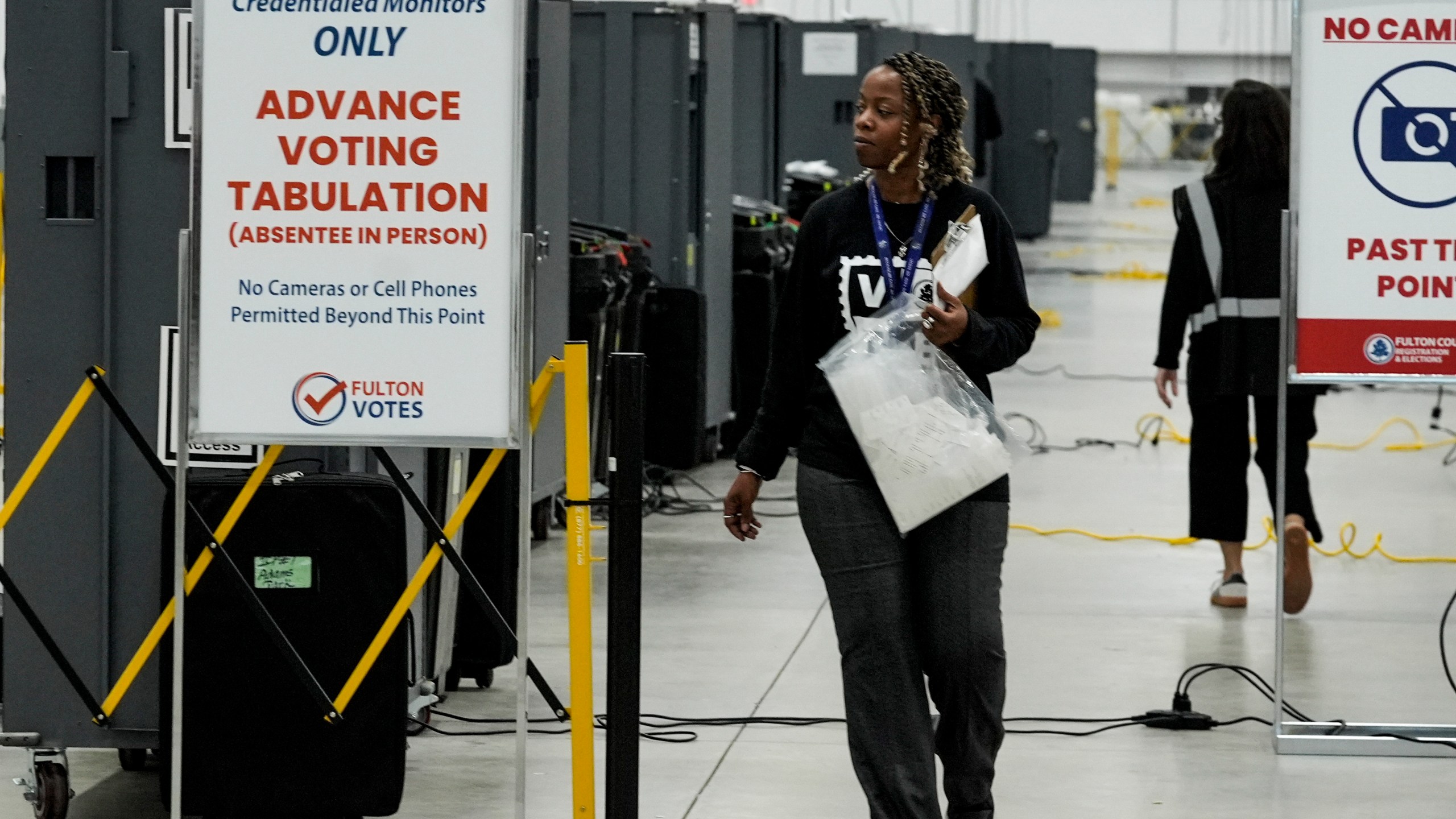 FILE - An election worker walks near voting machines at the Fulton County Election Hub and Operation Center, Nov. 5, 2024, in Atlanta. (AP Photo/John Bazemore, File)