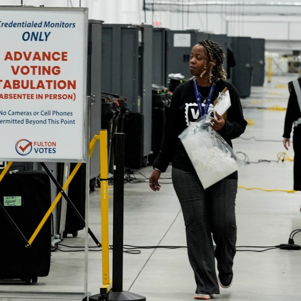 FILE - An election worker walks near voting machines at the Fulton County Election Hub and Operation Center, Nov. 5, 2024, in Atlanta. (AP Photo/John Bazemore, File)