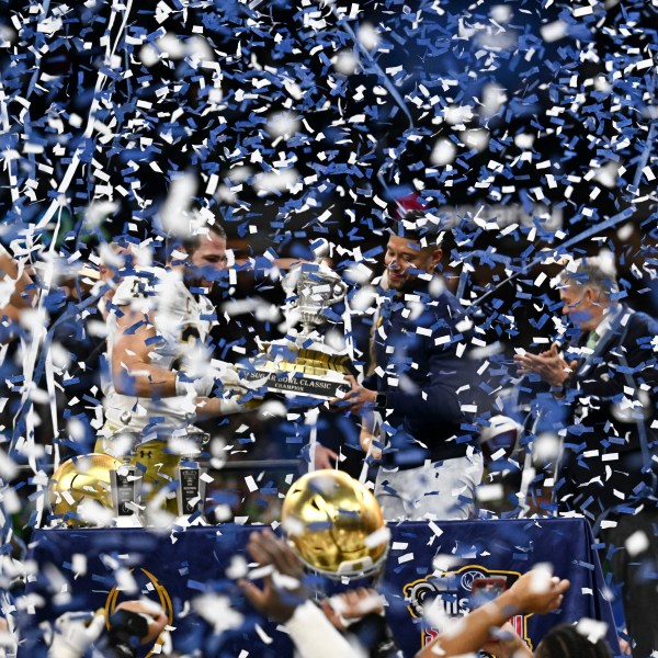 Notre Dame head coach Marcus Freeman celebrates with the trophy after a quarterfinal game against Georgia in a College Football Playoff, Thursday, Jan. 2, 2025, in New Orleans. (AP Photo/Matthew Hinton)