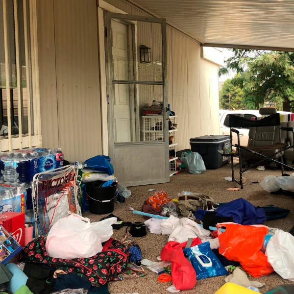 FILE - Cases of bottled water are seen with other items left on the porch of a house where killings occurred related to a Marijuana growing operation in Aguanga ,Calif., Tuesday, Sept. 8, 2020. (AP Photo/Elliot Spagat, File)