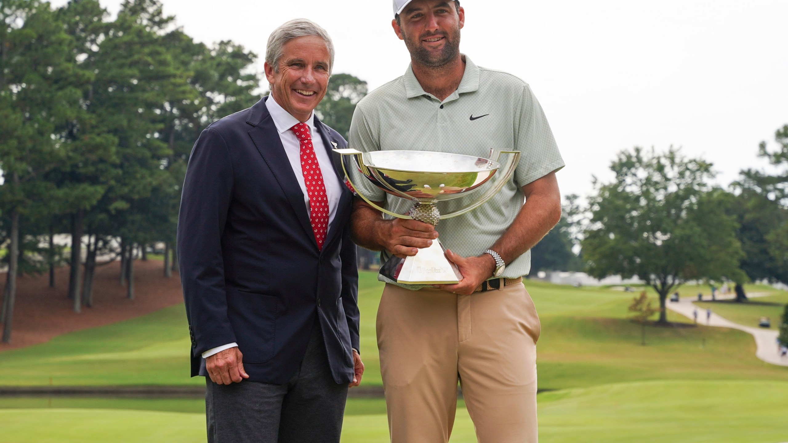 FILE - PGA Tour Commissioner Jay Monahan, left, poses with Scottie Scheffler and the FedExCup Trophy after Scheffler won the final round of the Tour Championship golf tournament, Sunday, Sept. 1, 2024, in Atlanta. (AP Photo/Jason Allen, File)