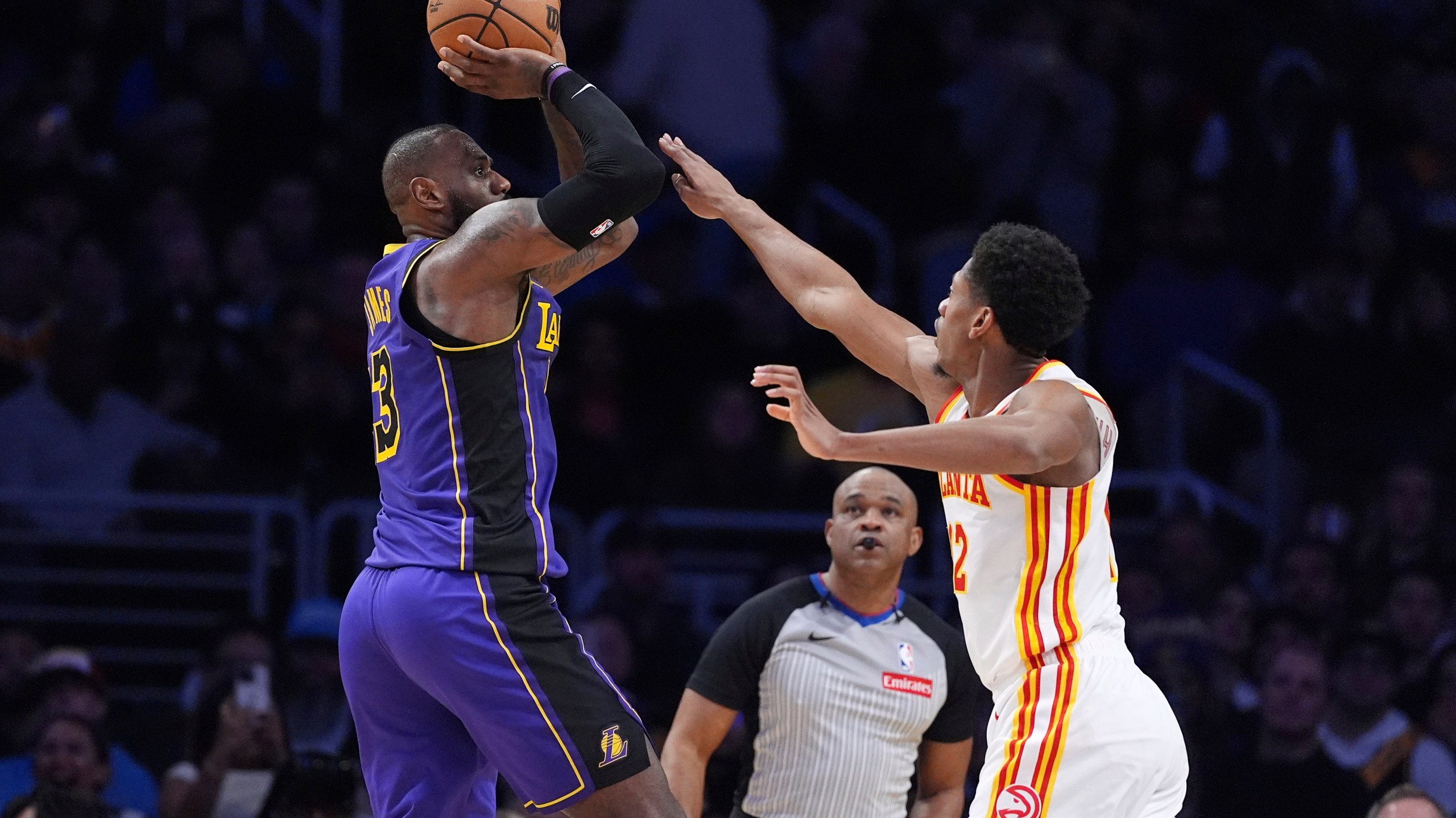 Los Angeles Lakers forward LeBron James, left, shoots as Atlanta Hawks forward De'Andre Hunter defends during the second half of an NBA basketball game, Friday, Jan. 3, 2025, in Los Angeles. (AP Photo/Mark J. Terrill)