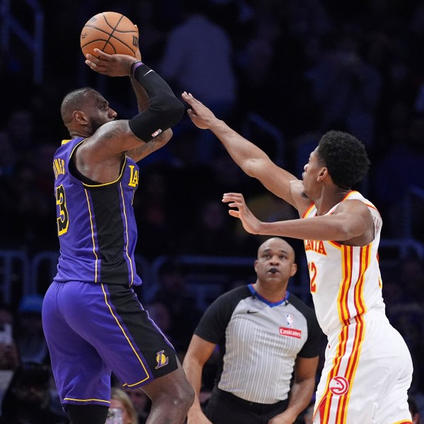 Los Angeles Lakers forward LeBron James, left, shoots as Atlanta Hawks forward De'Andre Hunter defends during the second half of an NBA basketball game, Friday, Jan. 3, 2025, in Los Angeles. (AP Photo/Mark J. Terrill)