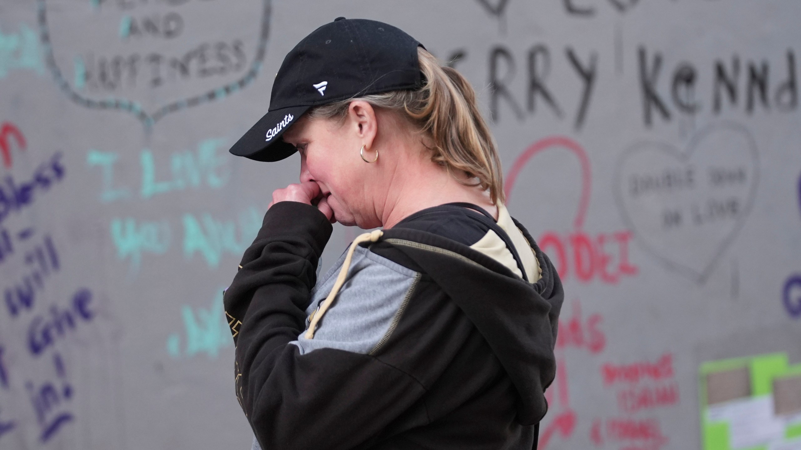 Alisa Kuhns, visiting from Santa Rosa, Calif. reacts at memorial on Bourbon Street for the victims of a deadly truck attack on New Year's Day in New Orleans, Friday, Jan. 3, 2025. (AP Photo/Gerald Herbert)