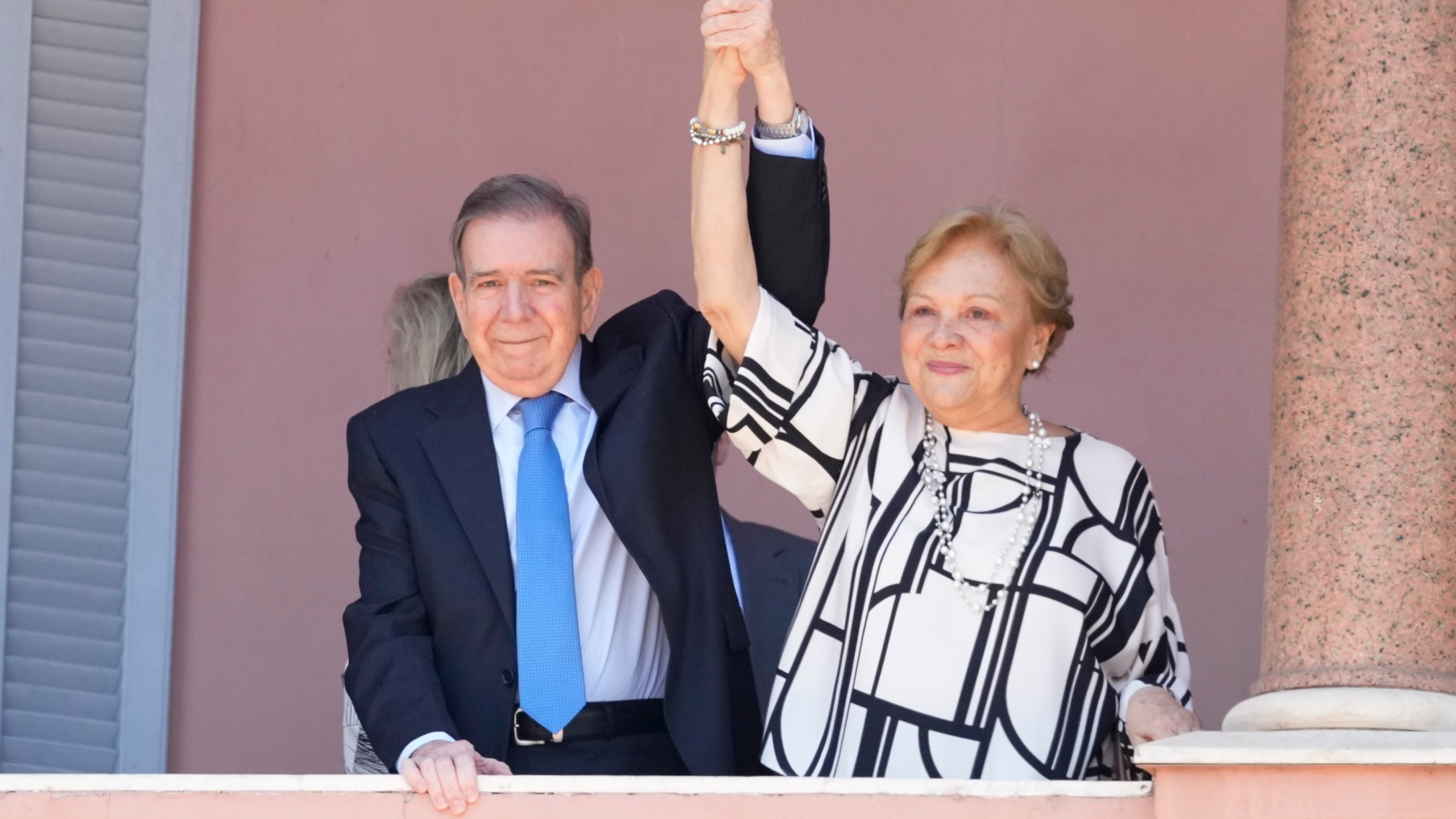 Venezuela's opposition leader Edmundo Gonzalez Urrutia and his wife Mercedes Lopez hold hands from the government house balcony in Buenos Aires, Argentina, Saturday, Jan. 4, 2025. Gonzalez, who claims he won the 2024 presidential election and is recognized by some countries as the legitimate president-elect, traveled from exile in Madrid to Argentina. (AP Photo/Natacha Pisarenko)