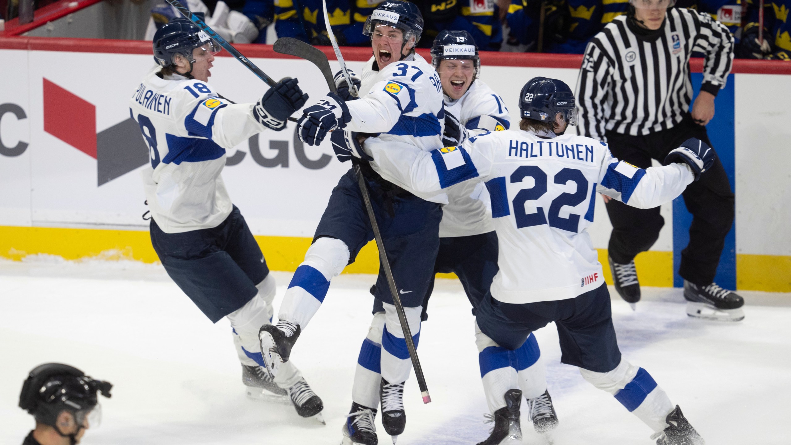 Finland's Benjamin Rautiainen (37) celebrates with teammates Rasmus Kumpulainen (18), Kasper Halttunen (22) and Konsta Helenius after scoring the game winning goal in overtime against Sweden in a semifinal game at the world junior hockey championship, Saturday, Jan. 4, 2025 in Ottawa, Ontario. (Adrian Wyld/The Canadian Press via AP)