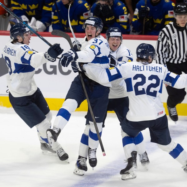 Finland's Benjamin Rautiainen (37) celebrates with teammates Rasmus Kumpulainen (18), Kasper Halttunen (22) and Konsta Helenius after scoring the game winning goal in overtime against Sweden in a semifinal game at the world junior hockey championship, Saturday, Jan. 4, 2025 in Ottawa, Ontario. (Adrian Wyld/The Canadian Press via AP)