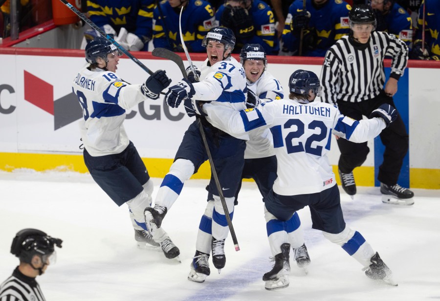 Finland's Benjamin Rautiainen (37) celebrates with teammates Rasmus Kumpulainen (18), Kasper Halttunen (22) and Konsta Helenius after scoring the game winning goal in overtime against Sweden in a semifinal game at the world junior hockey championship, Saturday, Jan. 4, 2025 in Ottawa, Ontario. (Adrian Wyld/The Canadian Press via AP)