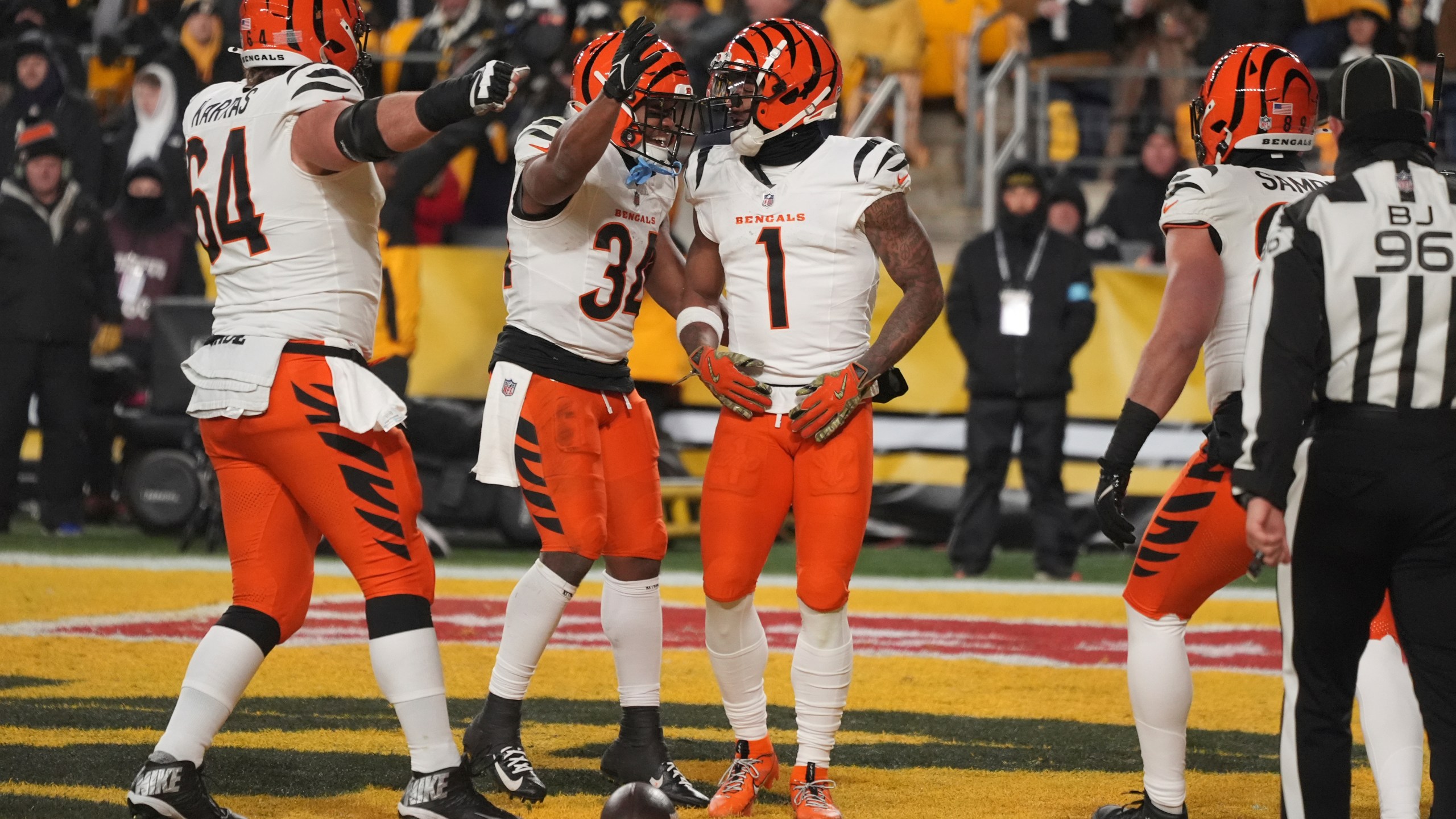 Cincinnati Bengals wide receiver Ja'Marr Chase (1) celebrates scoring a touchdown with center Ted Karras (64) and running back Khalil Herbert (34) during the first half of an NFL football game against the Pittsburgh Steelers in Pittsburgh, Saturday, Jan. 4, 2025. (AP Photo/Gene J. Puskar)