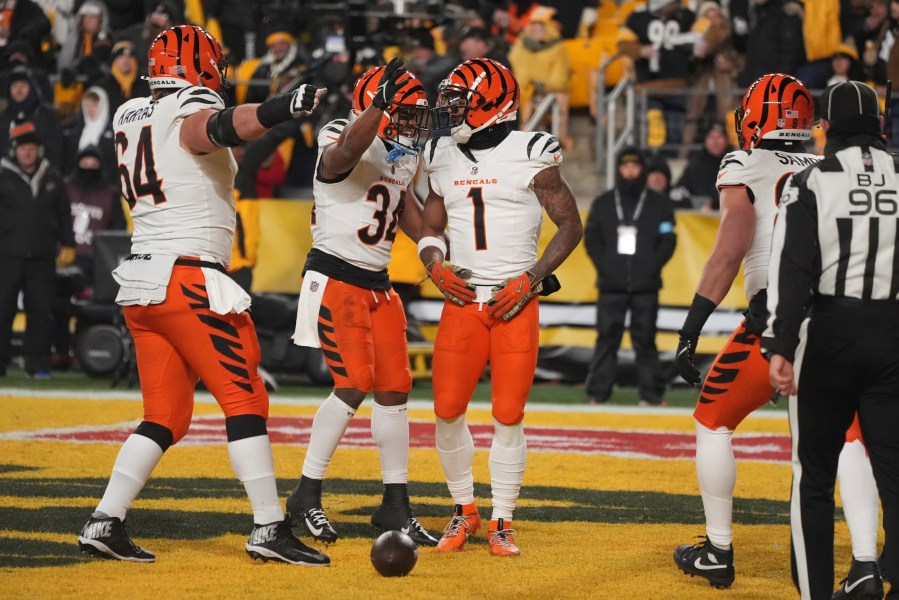 Cincinnati Bengals wide receiver Ja'Marr Chase (1) celebrates scoring a touchdown with center Ted Karras (64) and running back Khalil Herbert (34) during the first half of an NFL football game against the Pittsburgh Steelers in Pittsburgh, Saturday, Jan. 4, 2025. (AP Photo/Gene J. Puskar)