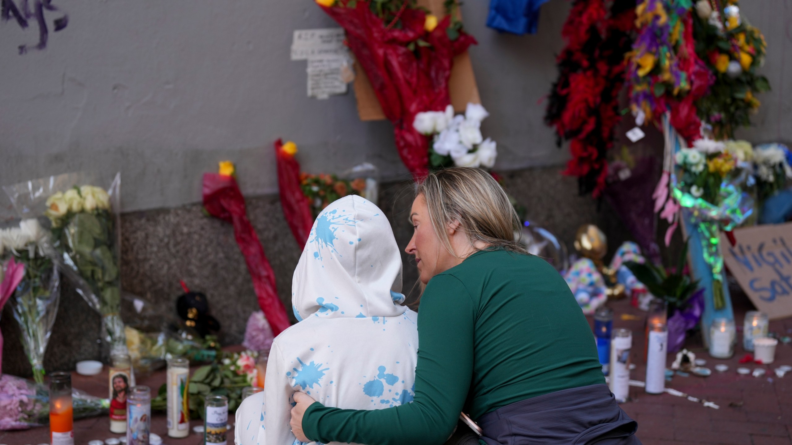 Kelli Galle, right, hugs her son Parker, left, as they visit a memorial to the victims of a deadly truck attack on Bourbon Street in the French Quarter, Friday, Jan. 3, 2025, in New Orleans. (AP Photo/George Walker IV)