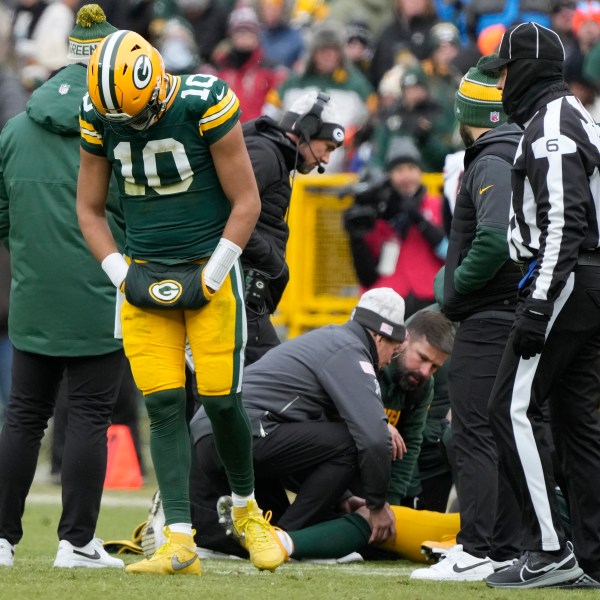 Green Bay Packers quarterback Jordan Love (10) reacts as wide receiver Christian Watson, bottom, is checked on during the first half of an NFL football game against the Chicago Bears, Sunday, Jan. 5, 2025, in Green Bay, Wis. (AP Photo/Morry Gash)