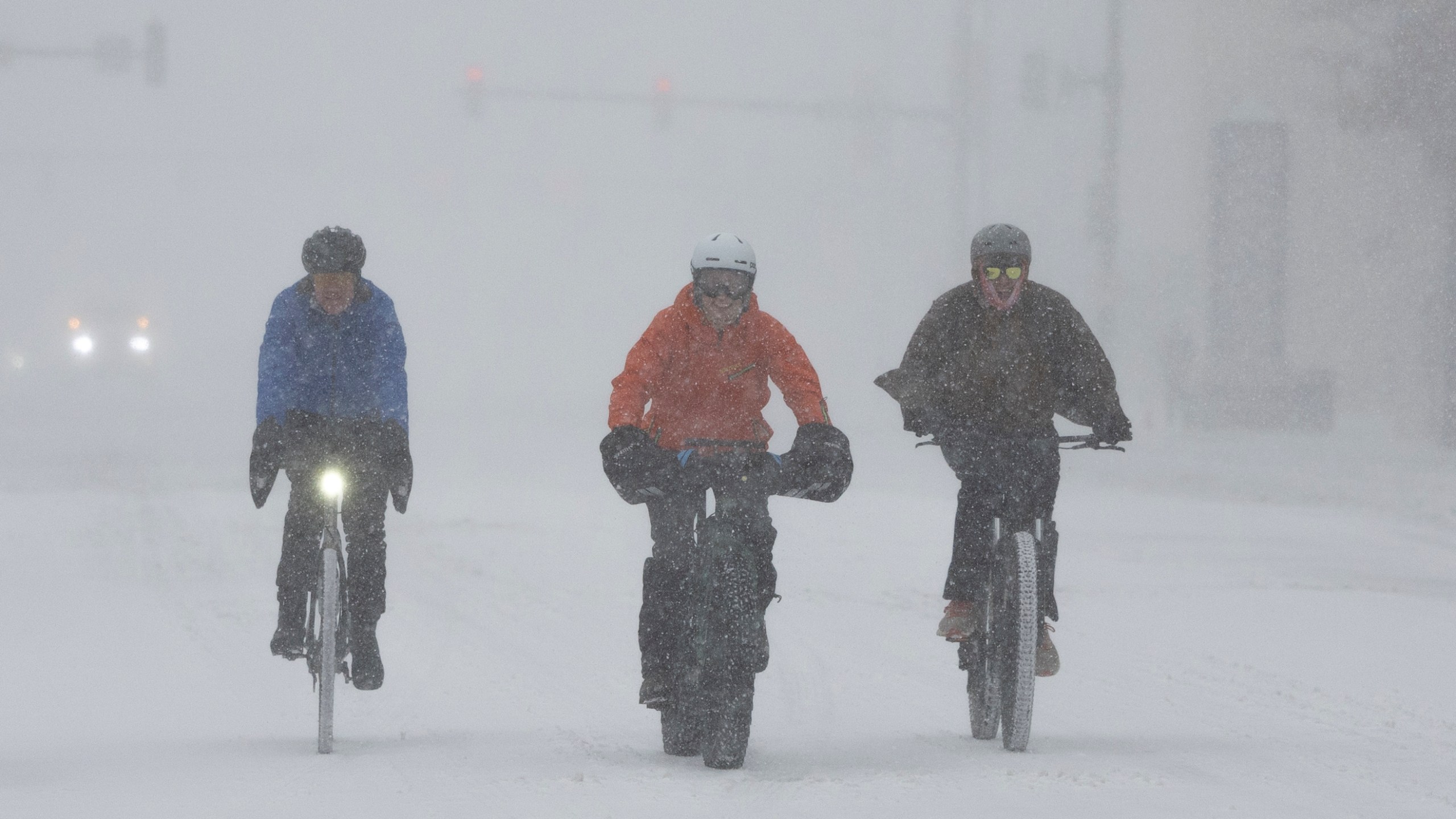 A group of cyclists make way through downtown Wichita, Kan., during a severe winter storm on Sunday, Jan. 5, 2025. (Travis Heying/The Wichita Eagle via AP)