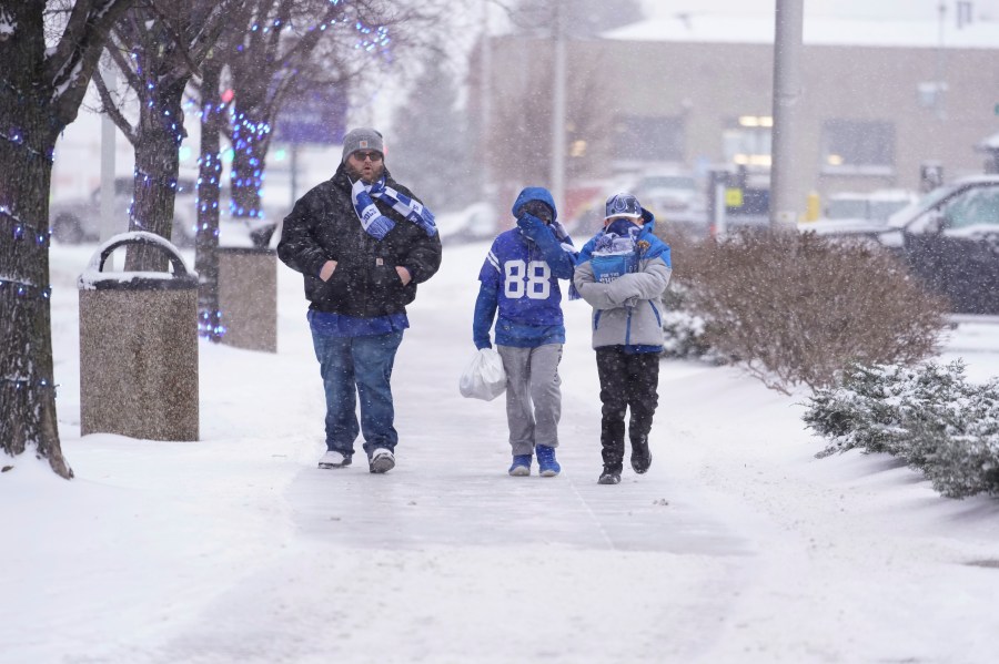 Indianapolis Colts fans walk in the falling snow after an NFL football game between the Colts and the Jacksonville Jaguars, Sunday, Jan. 5, 2025, in Indianapolis. (AP Photo/Michael Conroy)