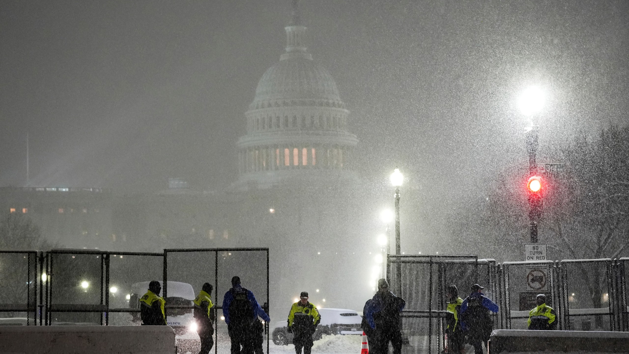 Law enforcement officers stand guard at the Capitol as snow falls ahead of a joint session of Congress to certify the votes from the Electoral College in the presidential election, in Washington, Monday, Jan. 6, 2025. (AP Photo/Matt Rourke)