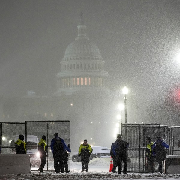 Law enforcement officers stand guard at the Capitol as snow falls ahead of a joint session of Congress to certify the votes from the Electoral College in the presidential election, in Washington, Monday, Jan. 6, 2025. (AP Photo/Matt Rourke)