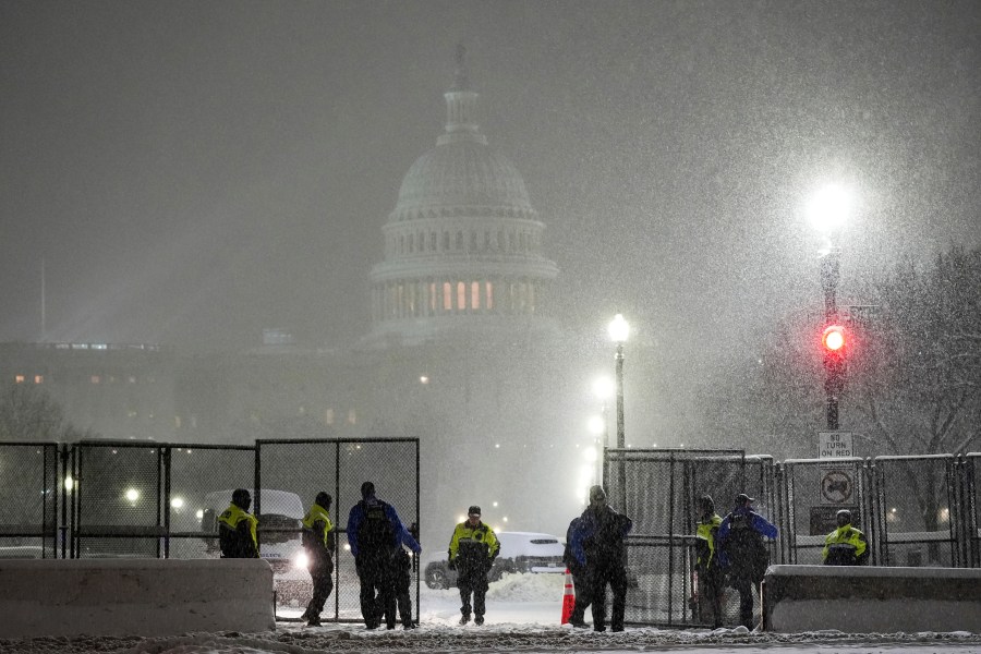 Law enforcement officers stand guard at the Capitol as snow falls ahead of a joint session of Congress to certify the votes from the Electoral College in the presidential election, in Washington, Monday, Jan. 6, 2025. (AP Photo/Matt Rourke)