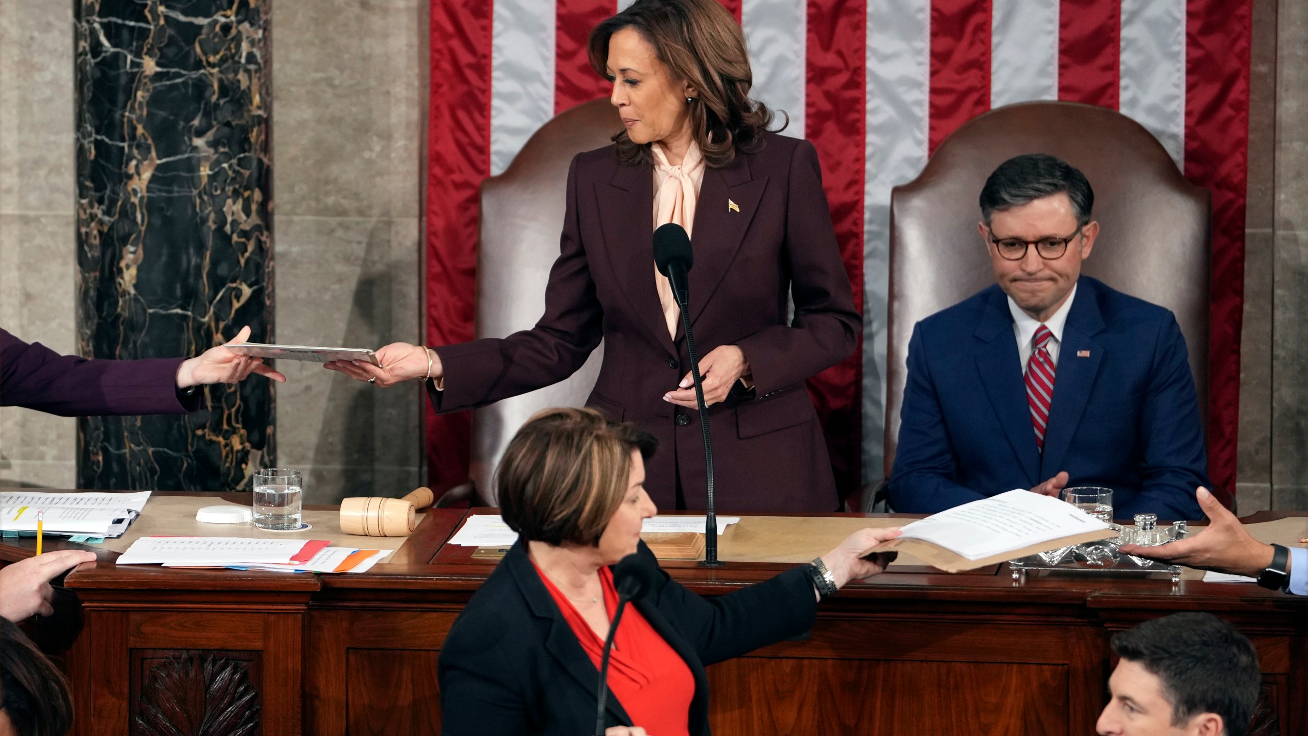 Vice President Kamala Harris is handed a certification as House Speaker Mike Johnson of La., watches while teller Sen. Amy Klobuchar, D-Minn., stands at the clerk's podium as a joint session of Congress convenes to confirm the Electoral College votes, affirming President-elect Donald Trump's victory in the presidential election, Monday, Jan. 6, 2025, at the U.S. Capitol in Washington. (AP Photo/Matt Rourke)