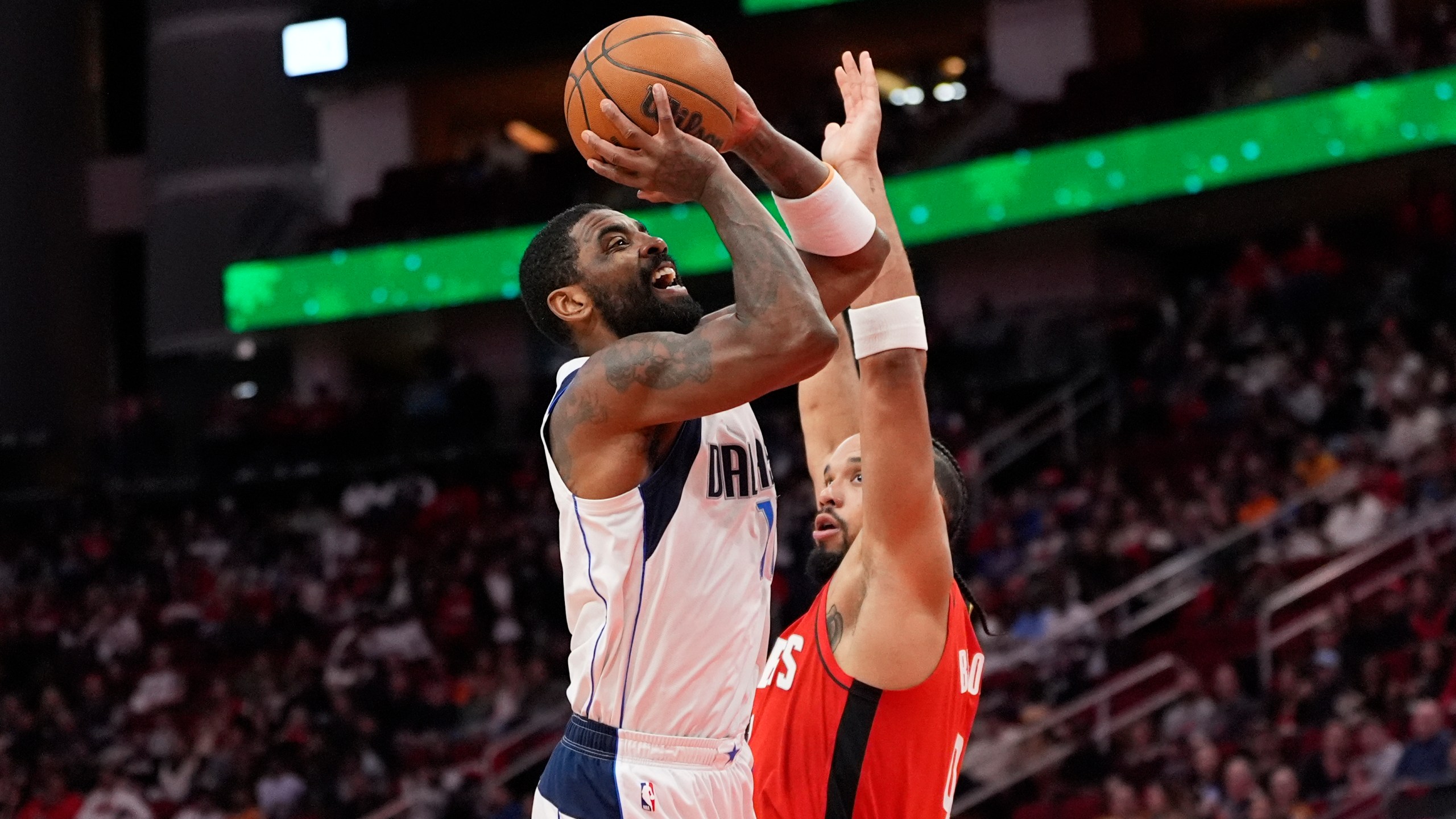 Dallas Mavericks' Kyrie Irving, left, shoots as Houston Rockets' Dillon Brooks defends during the first half of an NBA basketball game Wednesday, Jan. 1, 2025, in Houston. (AP Photo/David J. Phillip)