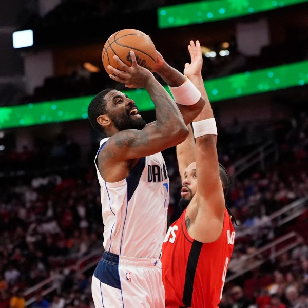 Dallas Mavericks' Kyrie Irving, left, shoots as Houston Rockets' Dillon Brooks defends during the first half of an NBA basketball game Wednesday, Jan. 1, 2025, in Houston. (AP Photo/David J. Phillip)