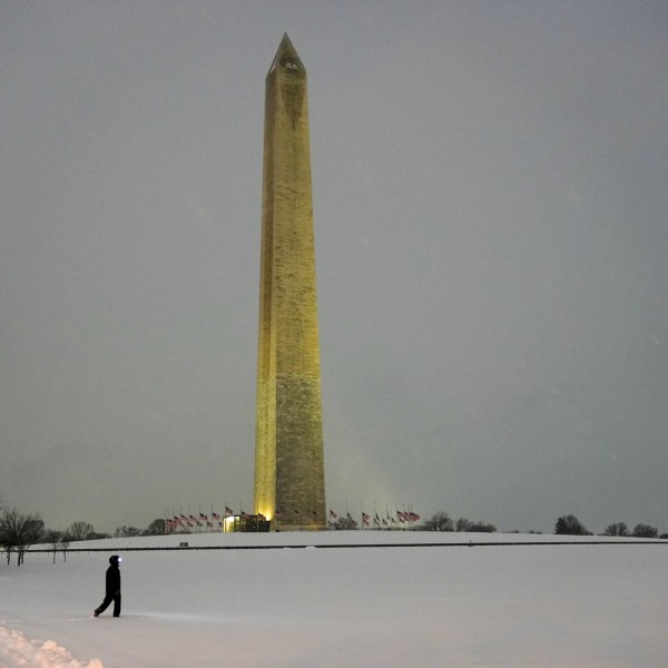 A person walks near the Washington Monument during a winter snow storm in Washington, Monday, Jan. 6, 2025. (AP Photo/Matt Rourke)