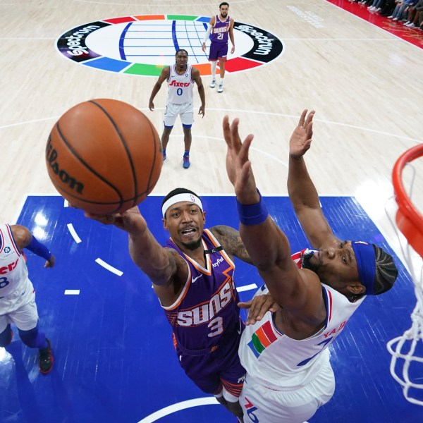 Phoenix Suns' Bradley Beal, center, goes up for a shot against Philadelphia 76ers' Guerschon Yabusele, right, during the first half of an NBA basketball game, Monday, Jan. 6, 2025, in Philadelphia. (AP Photo/Matt Slocum)