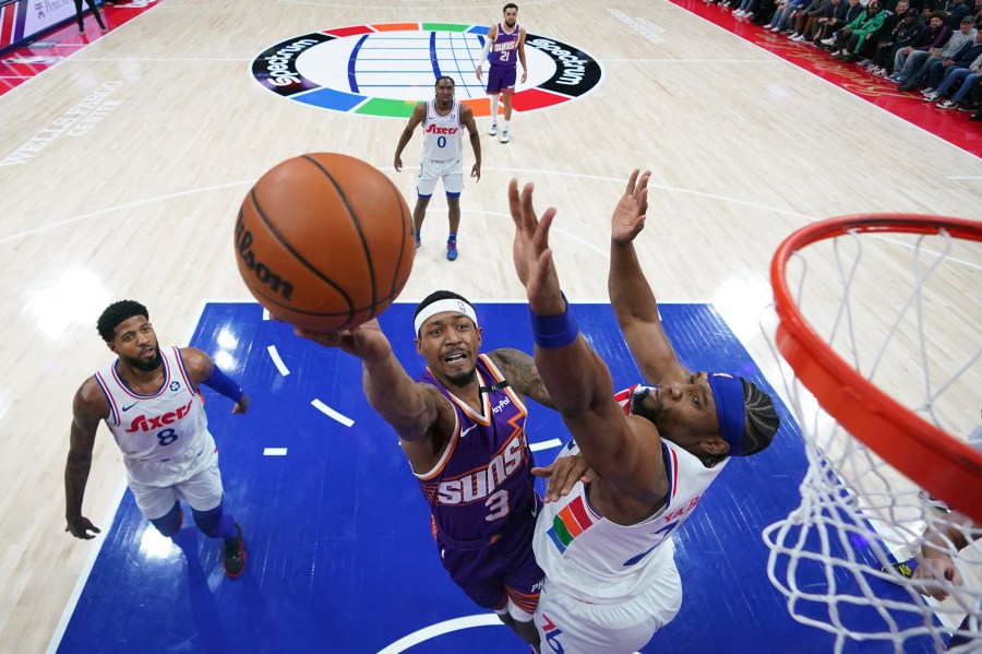 Phoenix Suns' Bradley Beal, center, goes up for a shot against Philadelphia 76ers' Guerschon Yabusele, right, during the first half of an NBA basketball game, Monday, Jan. 6, 2025, in Philadelphia. (AP Photo/Matt Slocum)