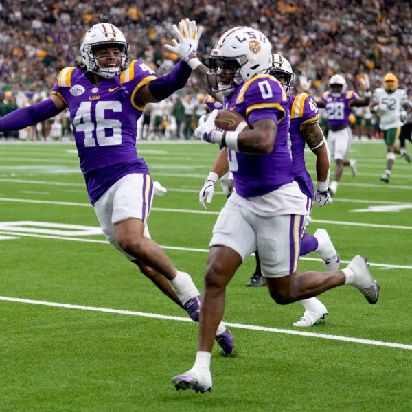 LSU linebacker Tylen Singleton, left, gives wide receiver Zavion Thomas (0) a high-five as Thomas returns a kickoff for a touchdown against Baylor during the first half of the Texas Bowl NCAA college football game Tuesday, Dec. 31, 2024, in Houston. (Brett Coomer/Houston Chronicle via AP)