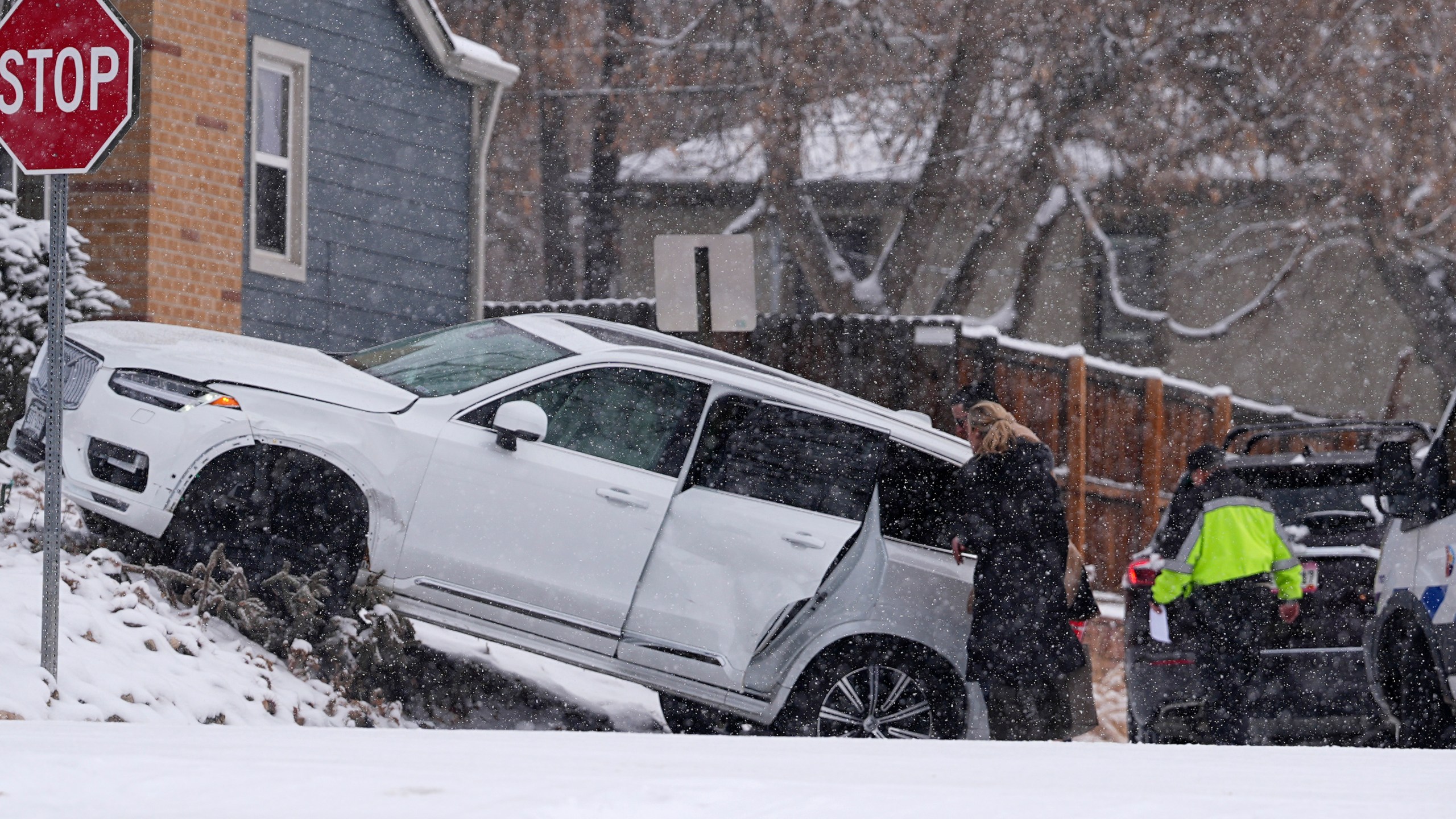 Motorists survey damage done to a utility vehicle in a crash at an intersection as a winter storm sweeps over the intermountain West and across the country Tuesday, Jan. 7, 2025, in southeast Denver. (AP Photo/David Zalubowski)