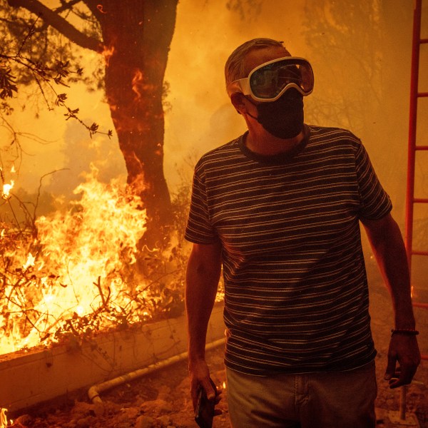 Will Adams watches as flames from the Palisades Fire close in on his property in the Pacific Palisades neighborhood of Los Angeles, Tuesday, Jan. 7, 2025. (AP Photo/Ethan Swope)